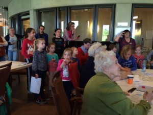 Jong & oud luisteren naar wethouder Coby Pennings tijdens creatieve/spel-middag in Polbeek