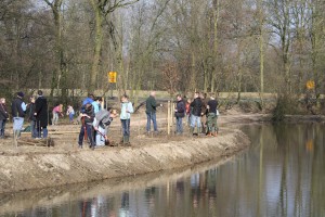 Het planten van diverse jonge bomen door de scholieren